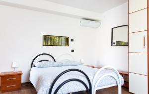 レッツェノにあるAppartamento Sosta sul Lagoの白いベッドルーム(ベッド1台、椅子2脚付)