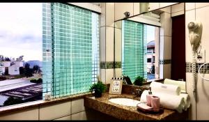 a bathroom with a sink and a large window at Flat bela vista master in Macaé