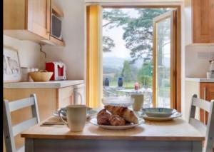een keuken met een tafel met een bord eten erop bij Mountain View Cottage, Hot Tub , Stunning Views in Llanhamlach