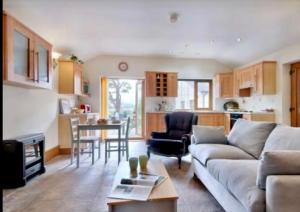 a living room with a couch and a table at Mountain View Cottage, Hot Tub , Stunning Views in Llanhamlach