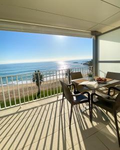 balcón con mesa y sillas y vistas a la playa en Apartaments Gibert, en Sant Antoni de Calonge