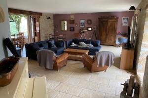 a living room with a blue couch and chairs at Holiday home in Loubressac with pool in Autoire
