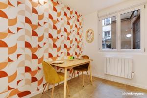 jadalnia ze stołem i ścianą geometryczną w obiekcie Cosy apartment - 1BR-4P - Sentier w Paryżu