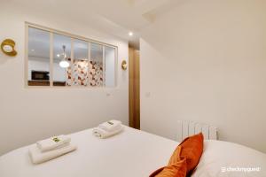 sypialnia z białym łóżkiem i ręcznikami na nim w obiekcie Cosy apartment - 1BR-4P - Sentier w Paryżu