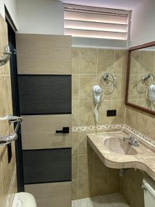 a bathroom with a sink and a phone at Hotel Plaza Real Ocaña in Ocaña