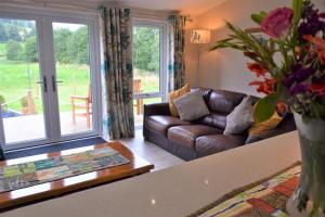 uma sala de estar com um sofá e uma mesa em Alderneuk Lodge em Dumfries