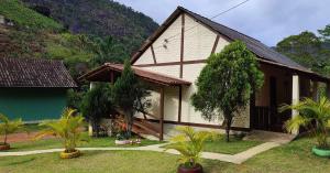 una pequeña casa con un edificio verde y blanco en Sítio e Pousada Vista Verde en Domingos Martins