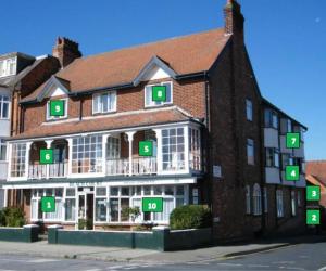 a large brick building with green numbers on it at Beach Court Holiday Apartments in Skegness