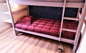 sypialnia z 2 łóżkami piętrowymi i czerwoną kołdrą w obiekcie Le Penty de Nalzu w mieście Saint-Yvy