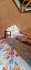 a room with two beds in a yurt at Nido del Quetrupillan Domo Geodésico in Curarrehue