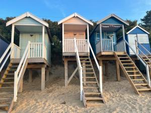a row of beach huts on a sandy beach at Fisherman's Retreat in Wells next the Sea