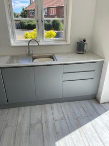 a kitchen with a sink and two windows at Fisherman's Retreat in Wells next the Sea