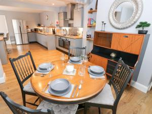 a dining room table with chairs and a kitchen at 9 Pilgrims Way in Roch
