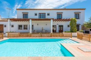 a villa with a swimming pool in front of a house at Casa Rural Aire in Fuente de Piedra