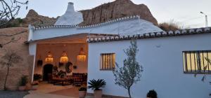 a white house with a mountain in the background at Cueva de la Higuera in Guadix