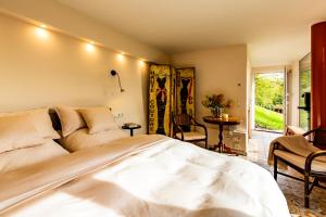 a bedroom with a large white bed and a patio at Hohenlohe Hideaway in Langenburg