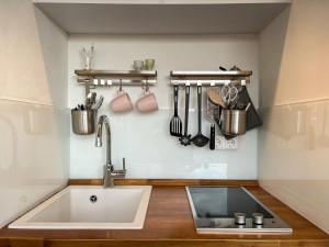 a kitchen with a sink and utensils on the wall at Hohenlohe Hideaway in Langenburg