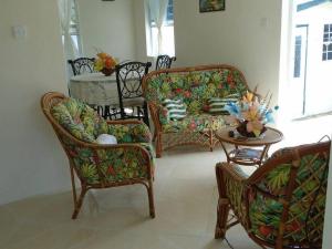 sala de estar con 2 sillas, sofá y mesa en Simply Beautiful Two Storey home/apt awaits you en Saint James