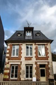 ein Backsteinhaus mit schwarzem Dach in der Unterkunft Appartement Cosy Au Sein De La Venise Normande in Pont-Audemer