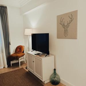 a living room with a flat screen tv on a white cabinet at SWEET HOME BILBAO in Bilbao