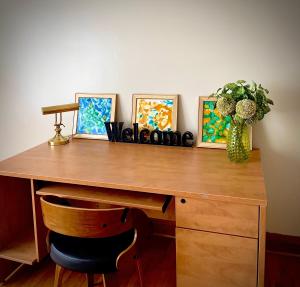 a desk with a vase on it with paintings on it at Charming Home Away from Home in Thunder Bay