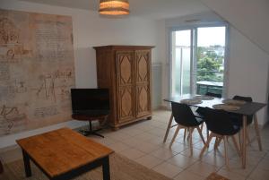 a living room with a dining room table and a tv at Appartement Leonard de Vinci in Montlouis-sur-Loire