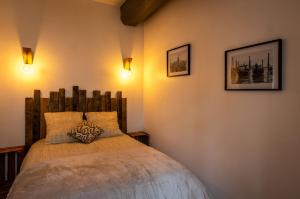 Schlafzimmer mit einem Bett mit einem Kopfteil aus Holz in der Unterkunft Appartement Cosy Au Sein De La Venise Normande in Pont-Audemer