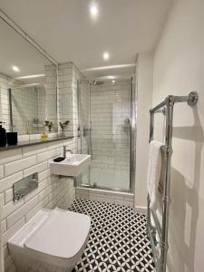 a bathroom with a toilet and a sink and a shower at Central Shoreditch Flat By Box Park & Spitalfields Market in London