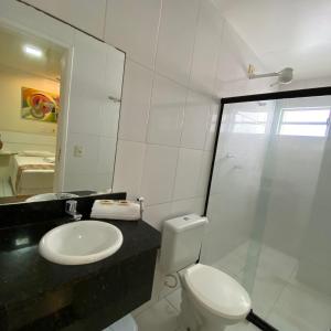 uma casa de banho com um WC, um lavatório e um espelho. em Hotel Monte Rei em Salvador