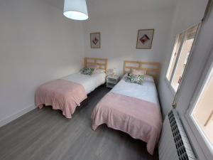 1 dormitorio con 2 camas con sábanas rosas y blancas en Acea Nova 3, en Monforte de Lemos