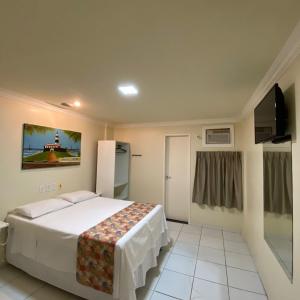 Hotel Monte Rei في سلفادور: غرفه فندقيه سرير وتلفزيون
