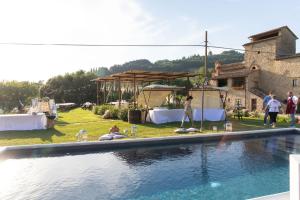 a group of people standing around a swimming pool at Casale Regnano in Lama