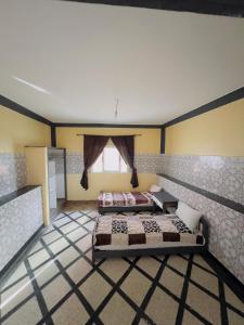 1 Schlafzimmer mit 2 Betten und einem Fenster in der Unterkunft maison de azoz in Oualidia
