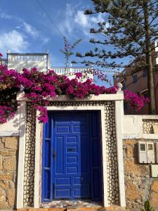 eine blaue Tür mit Blumen auf einem Gebäude in der Unterkunft maison de azoz in Oualidia