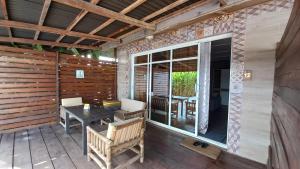 a screened in porch with a table and chairs at Tropicana Beach & Resort in Elwa