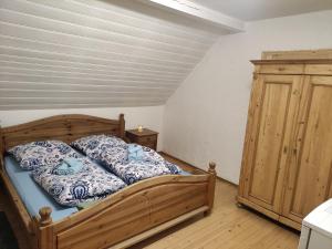 - une chambre avec un lit en bois et une armoire en bois dans l'établissement Zimmer Veljanovski, à Blaufelden