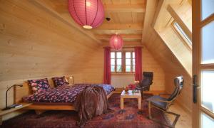 a bedroom in a log cabin with a bed and a chair at Willa Pawliki in Rzepiska