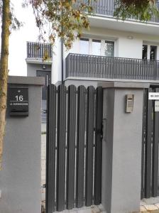 una cerca negra frente a una casa en Komfortowe przytulne nowoczesne mieszkanie Radom, en Radom