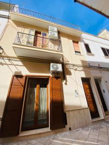 a building with wooden doors and a balcony at Nico's House in Brindisi