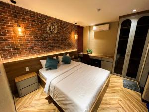 a bedroom with a bed and a brick wall at River View Hotel in Ho Chi Minh City