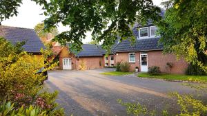 une maison avec une allée en face de celle-ci dans l'établissement Wohnung zwischen Nord- und Ostsee mit Fitnessraum, à Ostenfeld