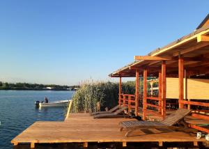 a dock with chairs and a boat on a lake at Masa L13 Stasa L14 in Ulcinj