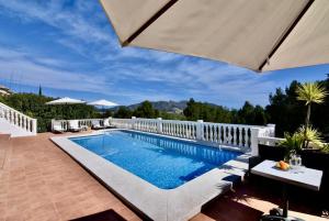 a swimming pool on a patio with an umbrella at Dream Villa in Benidoleig