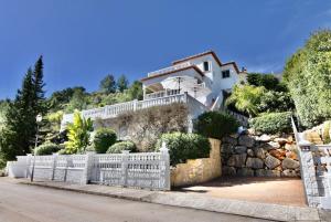 una casa en una colina con una valla blanca en Dream Villa, en Benidoleig