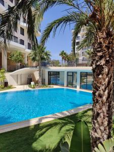 basen przed budynkiem z palmą w obiekcie Allonbay Beach & Nature SPA Apartment w mieście Villajoyosa