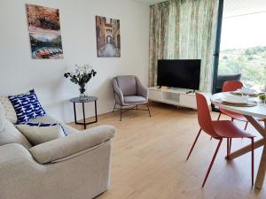salon z kanapą, stołem i telewizorem w obiekcie Allonbay Beach & Nature SPA Apartment w mieście Villajoyosa