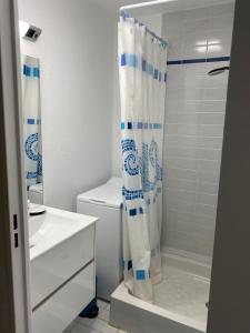 une salle de bain avec toilettes et rideau de douche dans l'établissement Les Rameaux, superbe appartement vue mer, Wimereux, à Wimereux