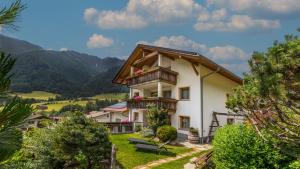 a house with a balcony and mountains in the background at Haus Alpenjuval in Fundres