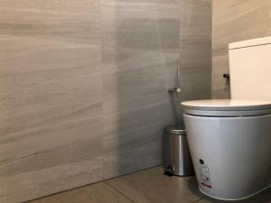 a bathroom with a toilet and a wall at Edge Central Pattaya By Alice in Pattaya