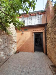 a brick building with a gate and a door at Casa Pozo de la Nieve in Iznatoraf